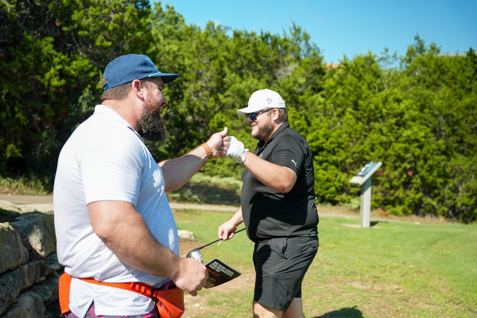 Two golfers at Hole 4, one holding an EVEN Media photo claim ticket