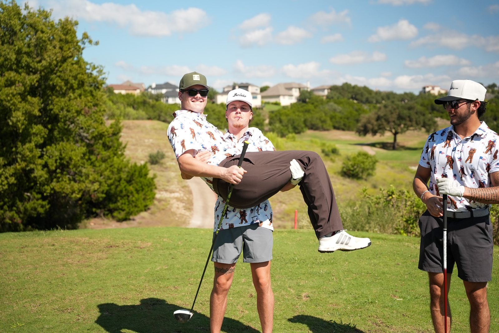 A foursome at Hole 4, one golfer carrying a teammate in his arms